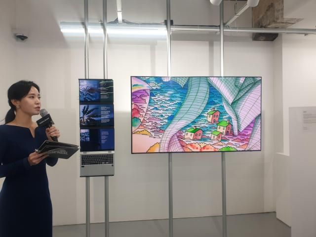 현장관계자가 태재 작가의 화분에게를 설명하고 있는 모습 태재 작가의 에세이 화분에게를 바탕으로 AI가 창조한 이미지가 디스플레이에 순차적으로 재생되고 있다