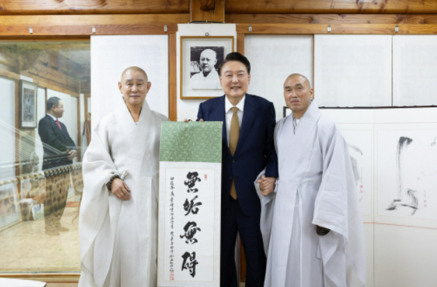 윤석열 대통령이 22일 부산 금정구 범어사를 찾아 차담 뒤 주지 정오스님오른쪽이 쓴 무구무애無垢無碍 족자를 선물 받은 뒤 기념촬영을 하고 있다 왼쪽부터 방장 정여스님 윤 대통령 주지 정오스님 사진대통령실 