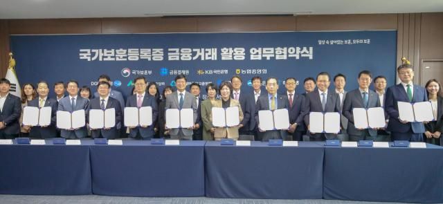 정애 국가보훈부 장관이 23일 오전 서울시 용산구 서울지방보훈청에서 열린 국가보훈등록증 진위확인서비스 업무협약식에 참석하여 박종석 금융결제원장 김범석 우리은행 부행장 등 8개 금융기관 대표자들과 함께 협약식에 서명후 기념촬영을 하고 있다사진국가보훈부