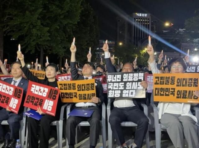 임현택 대한의사협회 회장가운데이 30일 밤 서울 덕수궁 대한문 앞에서 열린 대한민국 정부 한국의료 사망선고 촛불집회에 참석해 촛불을 높이 들어올리고 있다사진대한의사협회