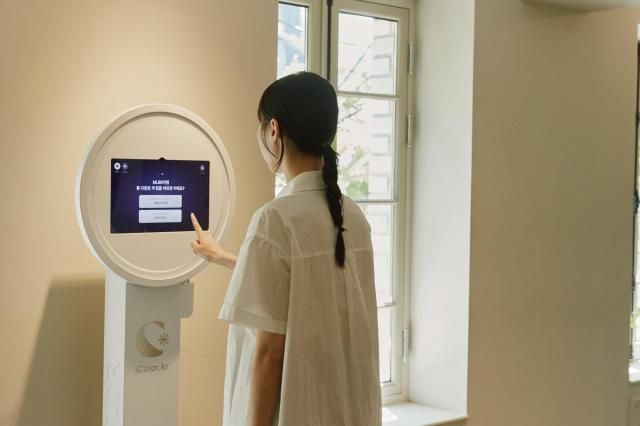 고객이 드파운드 팝업스토어 내 마련된 퍼스널 컬러 진단 키오스크를 이용 중이다 사진드파운드