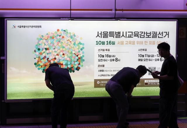 13일 오전 서울 지하철 3호선 충무로역 승강장 스크린 도어에 선관위 관계자들이 오는 10월 16일 실시하는 서울시교육감 보궐선거 홍보물을 부착하고 있다 2024913 사진연합뉴스 