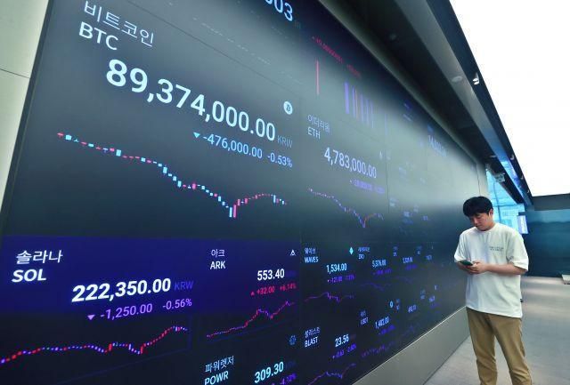 서울 강남구 업비트 라운지에 있는 암호화폐 시세 전광판 앞에서 관계자가 업무를 보고 있다 사진연합뉴스 