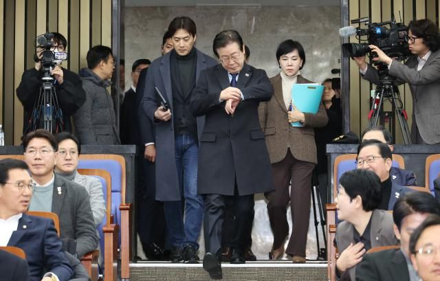 이재명 더불어민주당 대표가 15일 국회에서 열린 의원총회에 입장하며 시계를 보고 있다 사진연합뉴스