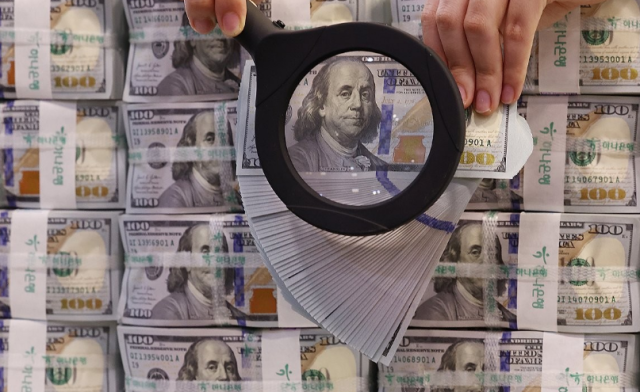 지난 10일 서울 중구 명동 KEB하나은행 위변조대응센터에서 직원이 미국 달러를 들어 보이고 있다 사진연합뉴스