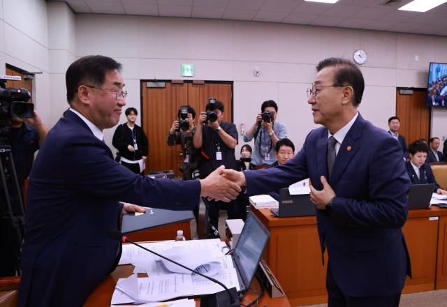 13일 서울 여의도 국회에서 열린 국토교통부 등에 대한 국토교통위원회 국정감사에서 김윤덕 국토교통부 장관이 선서문을 맹성규 국토교통위원장에게 전달한 뒤 악수하고 있다 사진연합뉴스