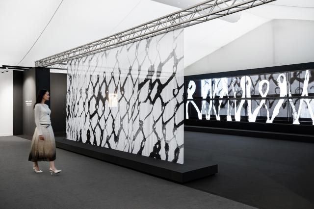 LG전자가 프리즈 런던에서 수묵 추상의 거장 고故 서세옥 화백의 작품을 재해석한 미디어아트를 선보인다 사진은 반투명 패브릭 너머로 전시 공간을 감상하는 모델의 모습 사진LG전자