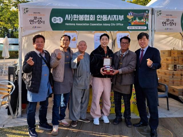 서울시청 앞 광장서 열린 2025왔니껴안동장터의 한 부스에서 안동 생산자와 김의승 전 서울시 행정부시장이 기념촬영을 하고 있다 사김의승 전 서울시 행정부시장