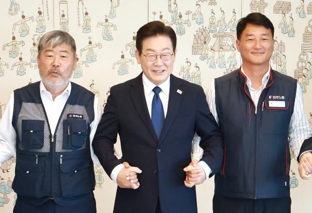 이재명 대통령이 지난 9월 4일 서울 용산 대통령실 청사에서 열린 양대노총 위원장과의 오찬 간담회에 참석해 김동명 한국노총 위원장왼쪽 양경수 민주노총 위원장과 기념촬영을 하며 손을 잡고 있다 사진연합뉴스