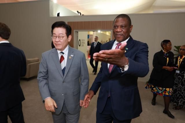 이재명 대통령이 22일현지시간 주요 20개국G20 정상회의가 열린 남아프리카공화국 요하네스버그 나스렉 엑스포센터에서 올해 의장국 남아프리카공화국의 폴 마샤틸레 부통령의 안내를 받으며 이동하고 있다 사진연합뉴스