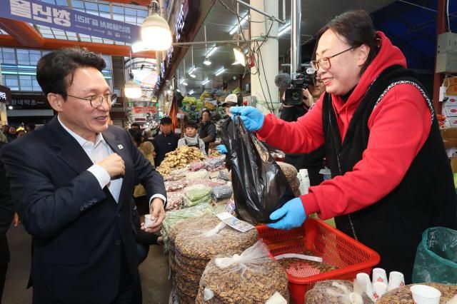 김민석 국무총리가 3일 서울 동대문구 경동시장에서 농축산물 물가 상황을 점검 물건을 구매하고 있다 사진연합뉴스