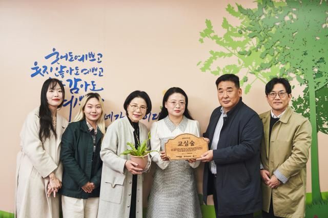 왼쪽 5번째 강진구 금호타이어 경영지원팀장 왼쪽 4번째 이귀염 서울세검정초등학교 교장이 교실숲 조성을 기념해 사진촬영을 하고 있다 사진금호타이어