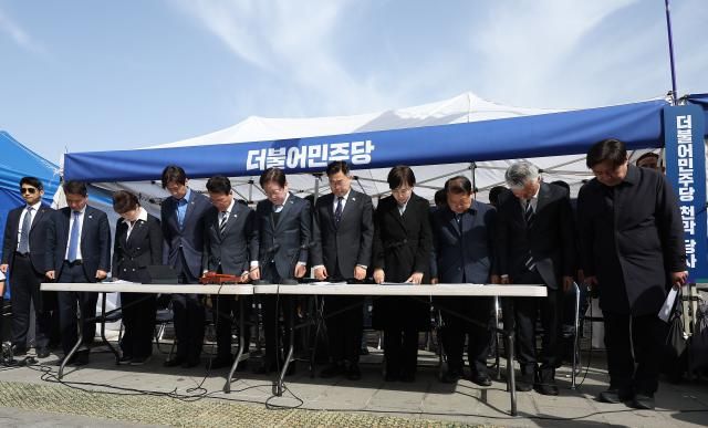 이재명 더불어민주당 대표와 박찬대 원내대표 등이 26일 서울 종로구 광화문 천막당사에서 열린 최고위원회의에서 산불 피해자들을 위해 묵념하고 있다 사진연합뉴스