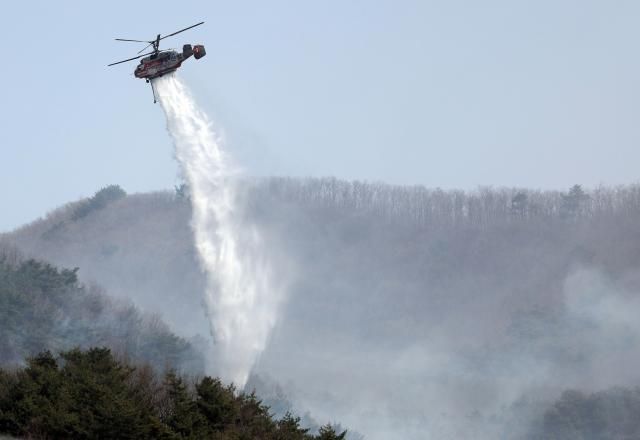 25일 경남 산청군 시천면 신천초등학교 주변 하늘에서 헬기가 산불 진화를 하고 있다 사진연합뉴스