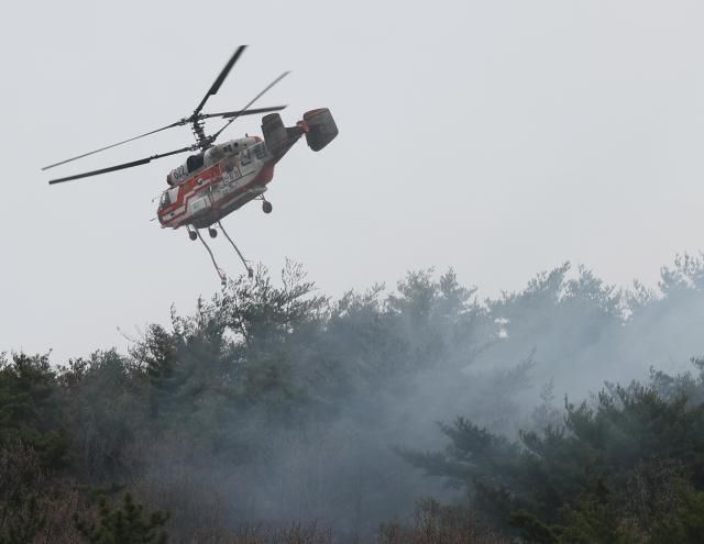 27일 엿새째 산불이 이어지고 있는 울산시 울주군 온양읍에서 진화 작업을 하는 산림청 헬기가 검게 그을려 있다 사진연합뉴스 