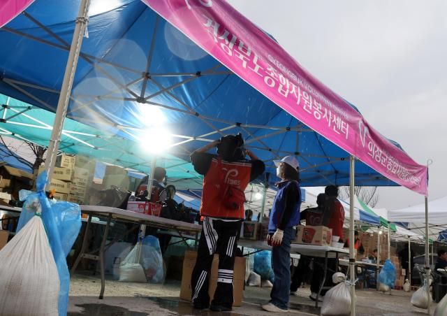 엿새째 산불이 잦아들고 있지 않은 27일 오후 6시 20분께 의성군청 임시청사에 비가 내리자 자원봉사자들이 기뻐하고 있다 하지만 비는 10여분 내리다가 그쳤다 사진연합뉴스