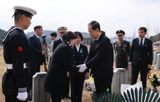 한덕수 대통령 권한대행 국무총리가 28일 국립대전현충원에서 천안함 피격 실종자 수색 도중 순직한 고故 한주호 준위 묘소를 찾아 참배 뒤 유족을 위로하고 있다 사진연합뉴스