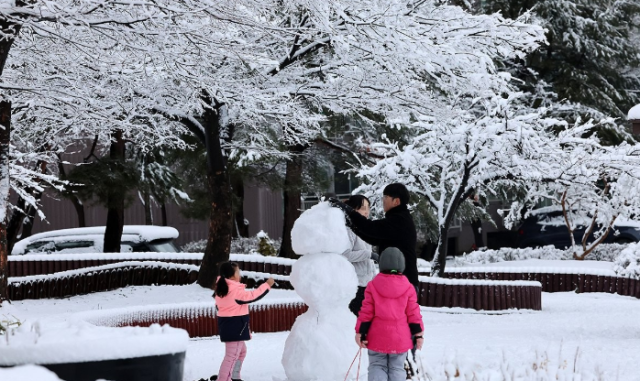 3일 강원 강릉시 교동의 주택가에서 한 가족이 눈사람을 만들고 있다 사진연합
