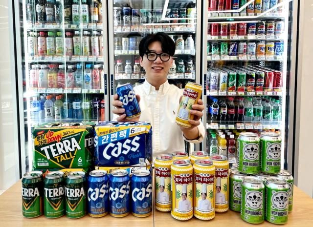 모델이 편의점 CU가 진행하는 치얼스 페스타의 할인 대상 제품을 들어보이고 있다 사진CU