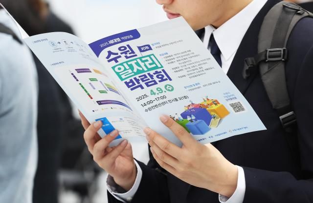  9일 경기도 수원시 영통구 수원컨벤션센터에서 열린 수원 일자리 박람회에서 구직자가 안내 책자를 살펴보고 있다 