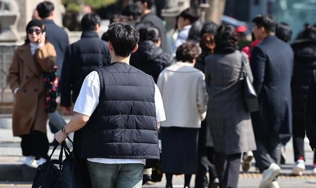 서울 최고기온이 10도까지 오르며 따듯한 날씨를 보인 6일 서울 종로구 광화문 네거리에서 반팔 티셔츠를 입은 시민이 외투를 손에 들고 이동하고 있다 사진연합뉴스