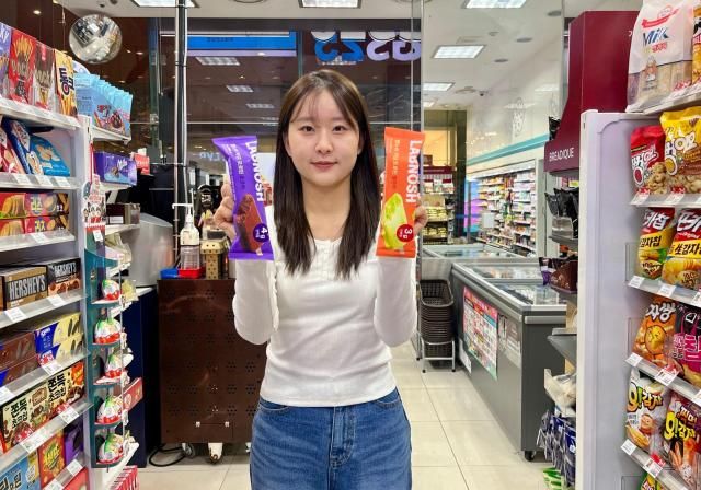 모델이 GS25에서 랩노쉬 저당 프로틴바 2종을 들고 포즈를 취하고 있다 사진GS리테일