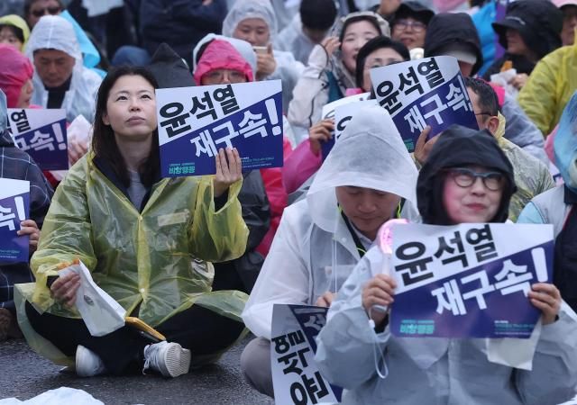 내란종식·사회대개혁 비상행동이 19일 서울 종로구 광화문광장 인근에서 연 시민행진에서 참가자들이 손팻말을 들고 있다 사진연합뉴스