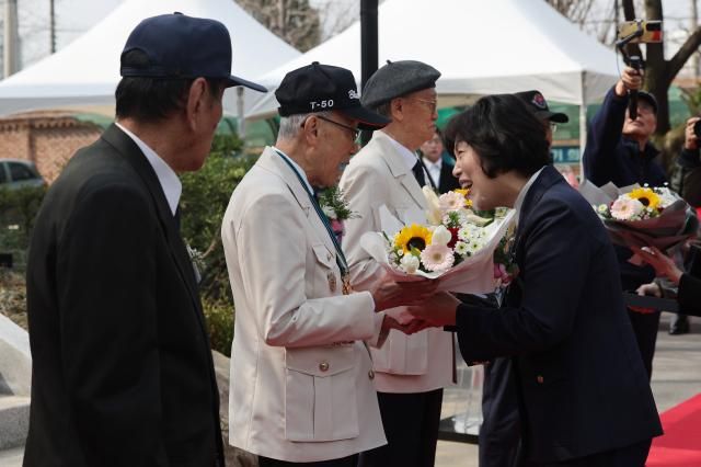 강정애 국가보훈부 장관이 지난 3월 24일 서울 용산고에서 열린 6·25 참전유공자 명비 제막식에서 6·25 참전유공자들에게 꽃다발을 전달하고 있다 사진연합뉴스 