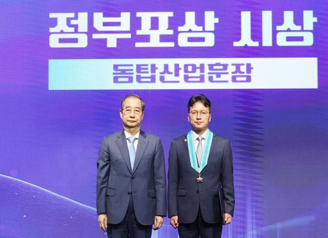 한덕수 대통령 권한대행 국무총리가 21일 서울 강남구 한국과학기술회관에서 열린 2025년 과학·정보통신의 날 기념식에서 도승용 SK하이닉스 부사장에게 동탑산업훈장을 전수한 뒤 기념촬영을 하고 있다 2025421 대통령실통신사진기자단 