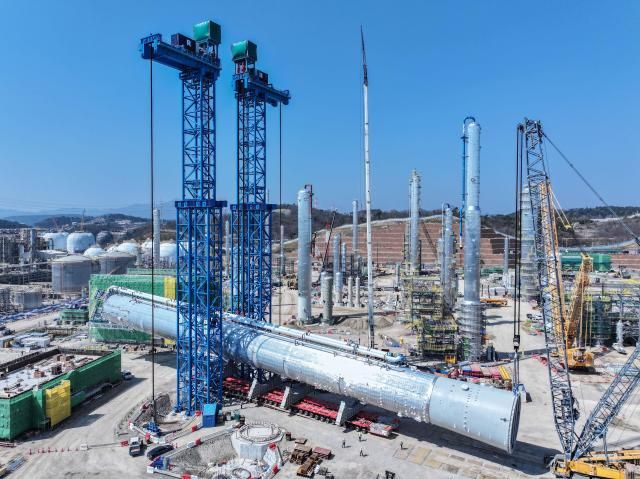 크롤러 크레인으로 현장으로 이송된 프로필렌 분리타워를 들어 올리고 있는 모습 사진에쓰오일