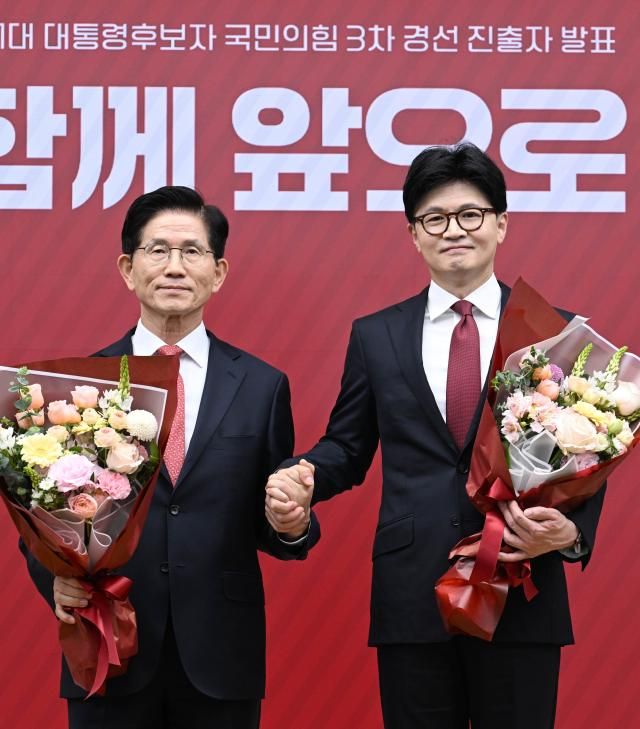 국민의힘 대선 최종 경선에 진출한 김문수왼쪽·한동훈 후보가 29일 서울 여의도 당사에서 3차 경선 결과 발표 후 꽃다발을 들고서 기념촬영 하고 있다 사진연합뉴스