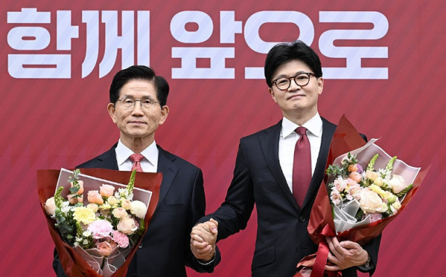 국민의힘 대선 최종 경선에 진출한 한동훈 후보오른쪽가 29일 서울 여의도 당사에서 3차 경선 결과 발표 후 김문수 후보와 꽃다발을 들고 기념촬영 하고 있다 사진연합뉴스