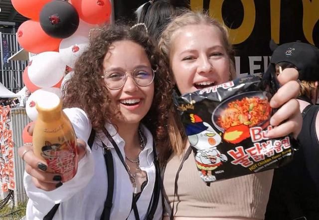 외국인들이 삼양식품 붉달볶음면과 불닭소스를 들어 보이고 있다 사진삼양식품