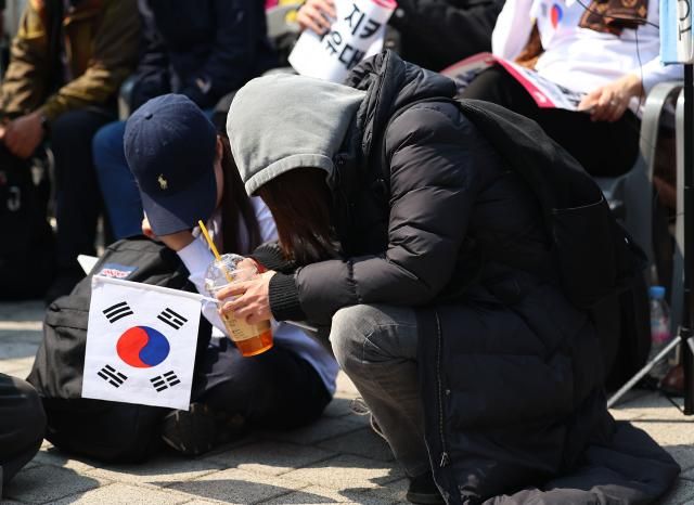 헌재의 윤석열 전 대통령 탄핵 인용이 발표된 4일 서울 용산 대통령실 인근에서 한 지지자가 주저앉아 있다사진연합뉴스