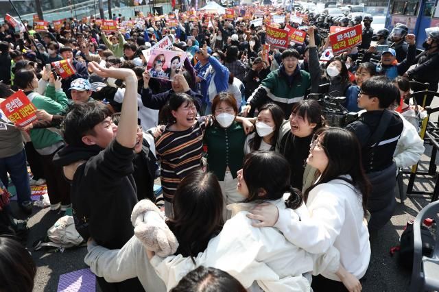  헌법재판소가 윤석열 대통령 탄핵 사건에 대해 인용을 선고한 4일 서울 종로구 안국동 일대에서 탄핵에 찬성한 시민들이 기뻐하고 있다 