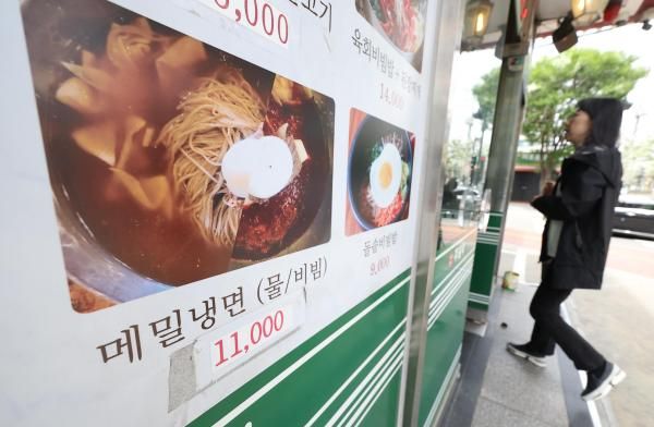 서울 시내 한 음식점에 냉면 그림 가격표 위에 오른 가격이 적힌 스티커가 붙어 있다 사진연합뉴스