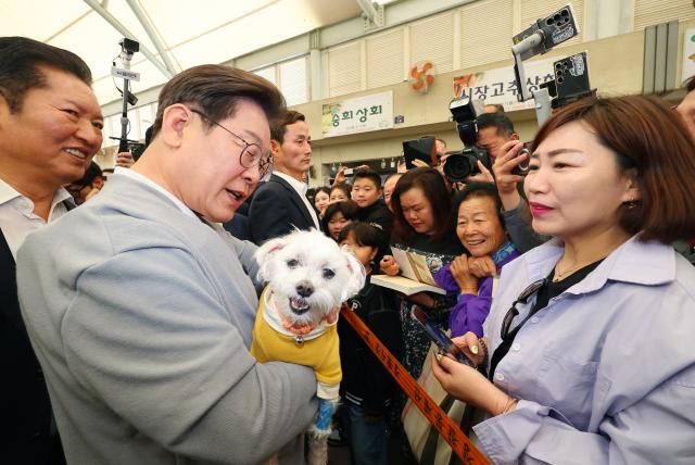 남도문화벨트 골목골목 경청투어에 나선 더불어민주당 이재명 대선 후보가 11일 전남 강진군 강진읍 강진오감통시장을 찾아 한 지지자의 반려견을 품에 안고 인사를 하고 있다 사진연합뉴스