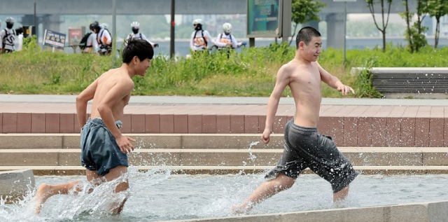 낮 최고기온이 20∼29도였던 13일 서울 영등포구 여의도물빛광장에서 현장체험학습을 마친 중학생들이 물놀이를 하며 더위를 식히고 있다 사진연합뉴스