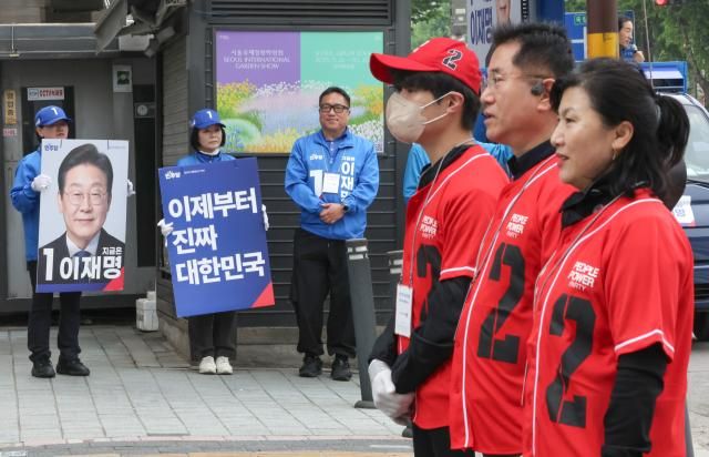 제21대 대통령 공식 선거운동 둘째날인 13일 서울 서대문구 한 거리에서 기호 1번 더불어민주당 이재명 2번 국민의힘 김문수 후보 선거운동원들이 시민들에게 인사하고 있다 사진연합뉴스