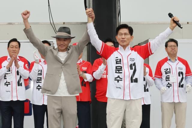 김문수 국민의힘 대선 후보가 16일 경기 수원시 지동시장에서 열린 유세에서 서해상에서 북한군에 의해 피살된 공무원의 유족인 이래진 씨와 함께 손을 들어 보이며 시민들에게 인사하고 있다 사진연합뉴스