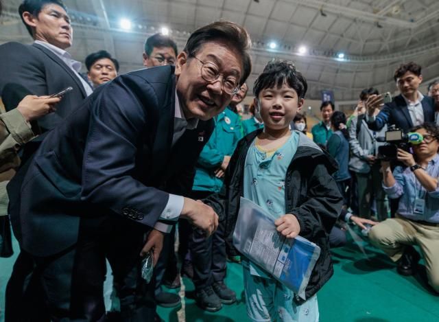 더불어민주당 이재명 대선후보가 17일 광주광역시 광산구 광주여대 체육관에 마련된 금호타이어 공장 화재 이재민 대피소를 찾아 악수를 요청하는 어린이와 악수하고 있다 사진연합뉴스