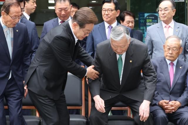 이재명 더불어민주당 대선 후보가 19일 서울 용산구 대한노인회관을 방문 기념촬영 자리에 앉는 이중근 회장을 부축하고 있다 사진연하뷴스