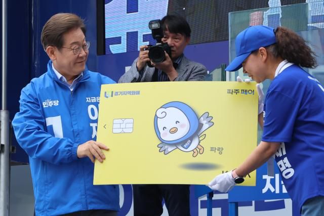 이재명 더불어민주당 대선 후보가 20일 경기 파주시 금릉역 중앙광장에서 열린 유세에서 지역화폐 모형을 전달받고 있다 사진연합뉴스
