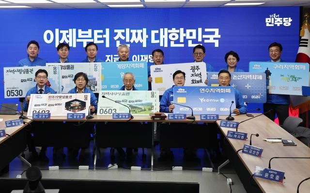 21일 서울 여의도 당사에서 열린 중앙선거대책위원회의에서 더불어민주당 윤여준 총괄선대위원장을 비롯한 참석자들이 지역화폐 활성화를 촉구하는 퍼포먼스를 하고 있다사진연합뉴스