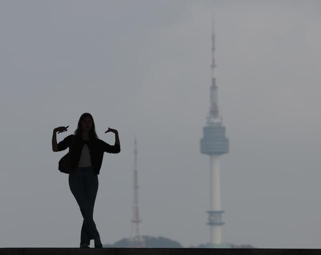 서울 용산구 국립중앙박물관을 찾은 외국인 관광객이 남산타워를 배경으로 기념촬영을 하고 있다. [사진=연합뉴스]
