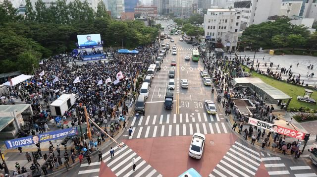 이재명 더불어민주당 대선 후보의 집중유세가 열린 28일 서울 왕십리역 광장에서 시민들이 이 후보의 연설을 듣고 있다 사진연합뉴스