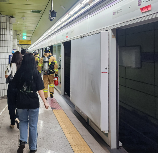 소방대원들이 31일 오전 서울 지하철 5호선 마포역 인근 화재 현장에서 승객들의 대피를 돕고 있다 사진연합뉴스