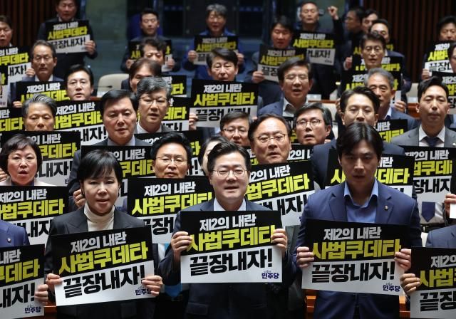 더불어민주당 박찬대 원내대표를 비롯한 의원들이 4일 국회에서 열린 긴급 의원총회에서 대법원 규탄 팻말을 들고 구호를 외치고 있다 사진연합뉴스