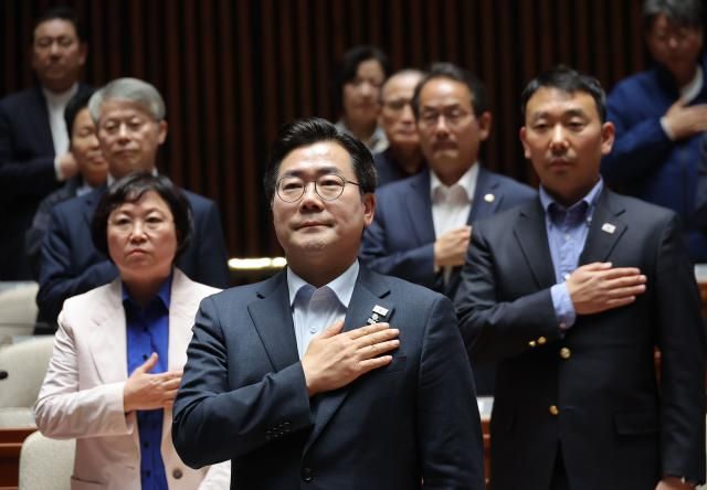 박찬대 더불어민주당 원내대표를 비롯한 의원들이 4일 국회에서 열린 긴급 의원총회에서 국기에 경례를 하고 있다 사진연합뉴스