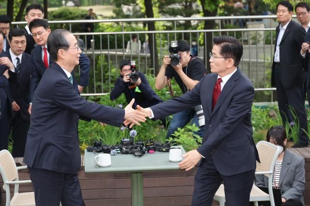 김문수 국민의힘 대선 후보와 한덕수 무소속 예비후보가 8일 서울 국회 사랑재에 위치한 커피숍에서 회동을 마친 후 악수하고 있다 사진연합뉴스